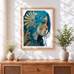 Finished blue haired woman with gold sun cross stitch artwork displayed