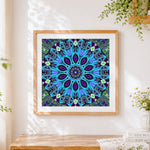Finished blue kaleidoscope mandala cross stitch artwork displayed