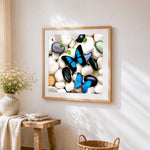 Blue morpho butterflies on white pebbles cross stitch artwork displayed on wall as home decor