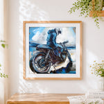 Finished blue motorcycle rider cross stitch artwork displayed