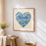 Blue multi language heart cross stitch artwork displayed on wall as home decor