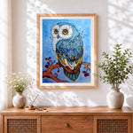 Finished blue owl and stars cross stitch artwork displayed