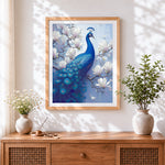 Finished blue peacock on magnolia branch cross stitch artwork displayed