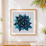 Finished blue succulent plant cross stitch artwork displayed