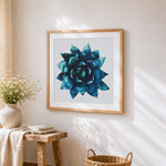Blue succulent plant cross stitch artwork displayed on wall as home decor