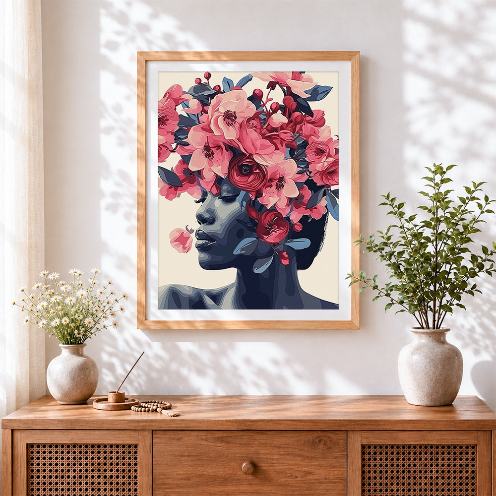 Finished blue toned woman with pink blossoms cross stitch artwork displayed