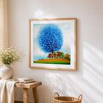 Blue tree and colourful village cross stitch artwork displayed on wall as home decor