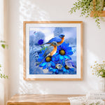 Finished bluebirds and blue flowers cross stitch artwork displayed
