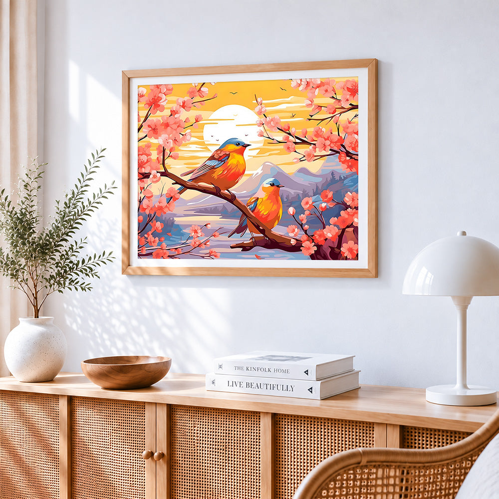 Bluebirds on a cherry blossom branch at sunset cross stitch artwork displayed on wall as home decor