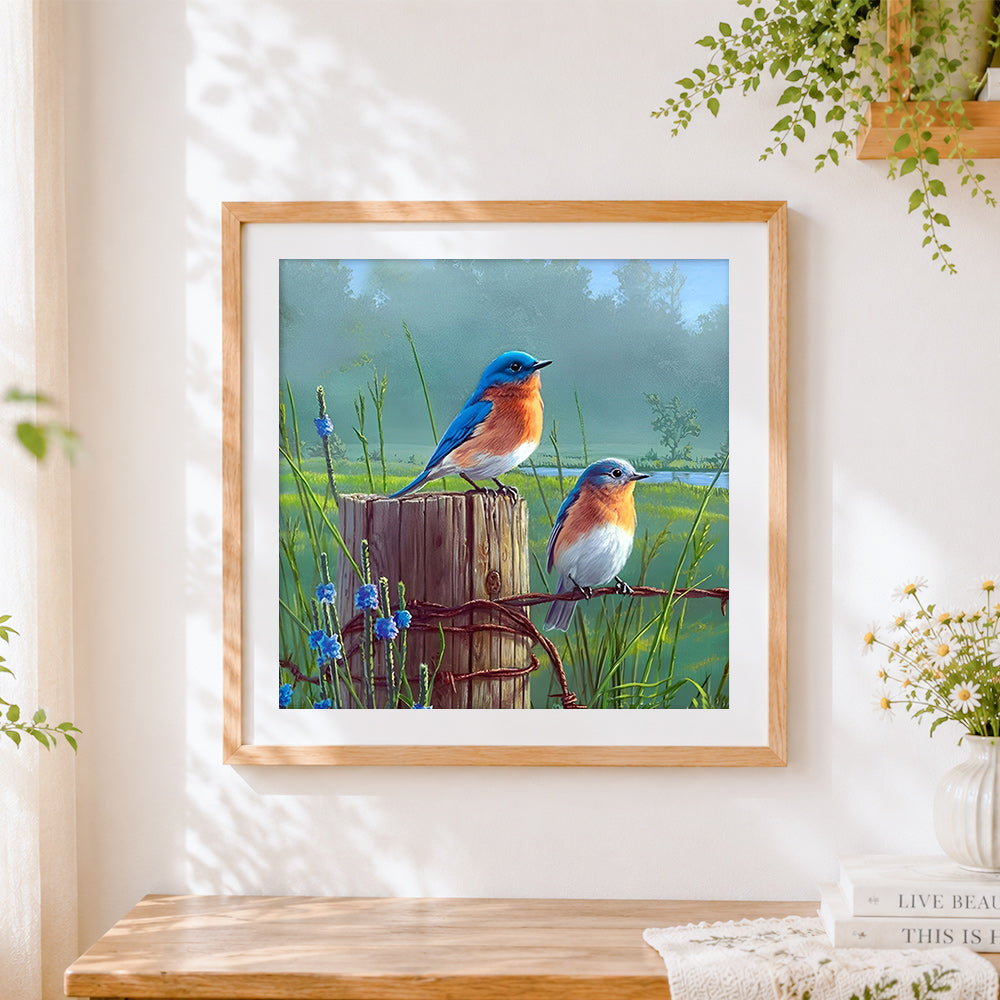 Finished bluebirds on a rustic fence cross stitch artwork displayed