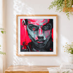 Finished bold red and black abstract portrait cross stitch artwork displayed