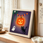Bright glowing pumpkin punch needle artwork displayed on a table