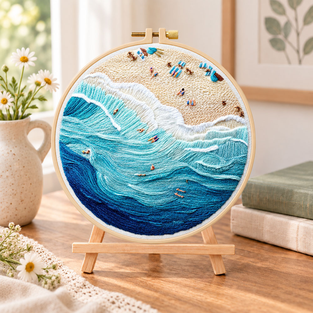 Bustling ocean surf embroidery kit finished hoop displayed on a wooden stand as cosy tabletop decor