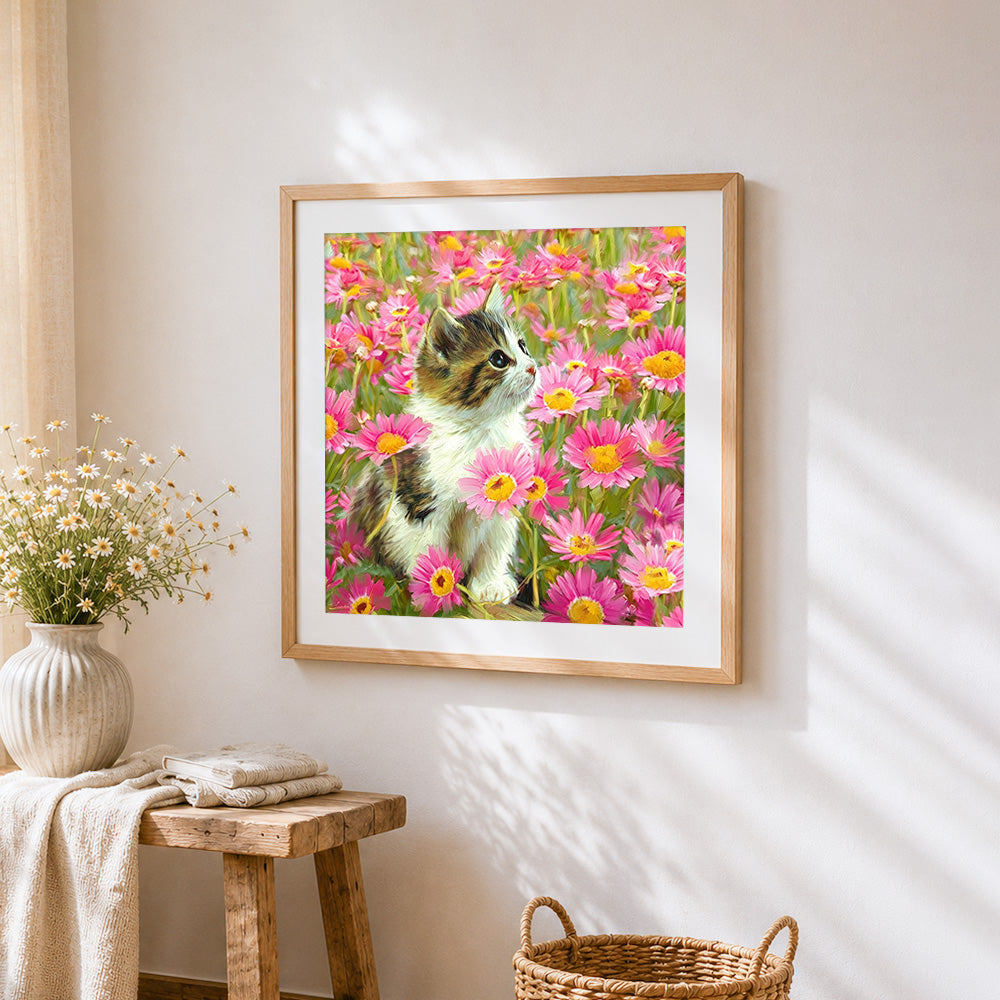 Calico kitten in pink daisies cross stitch artwork displayed on wall as home decor