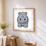 Cartoon hippo sitting cross stitch artwork displayed on wall as home decor