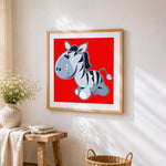 Cartoon zebra on red background cross stitch artwork displayed on wall as home decor