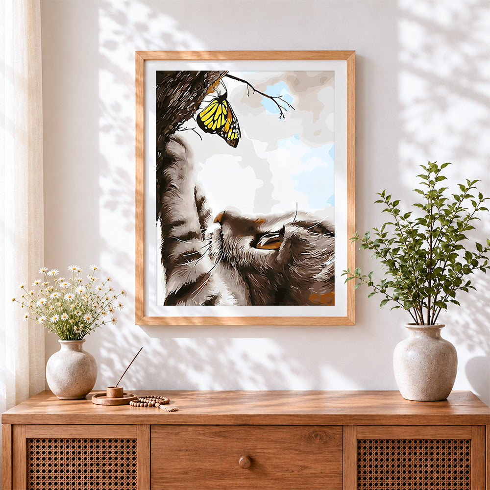 Finished cat and yellow butterfly cross stitch artwork displayed