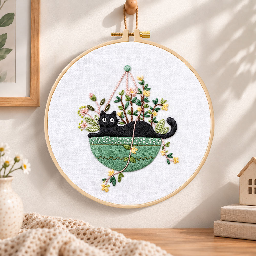 Cat in green hanging pot embroidery hoop wall art displayed as warm and cosy handmade home decor