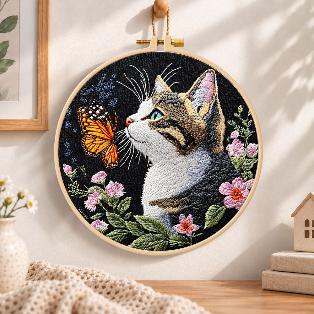Cat meets monarch butterfly embroidery hoop wall art displayed as warm and cosy handmade home decor