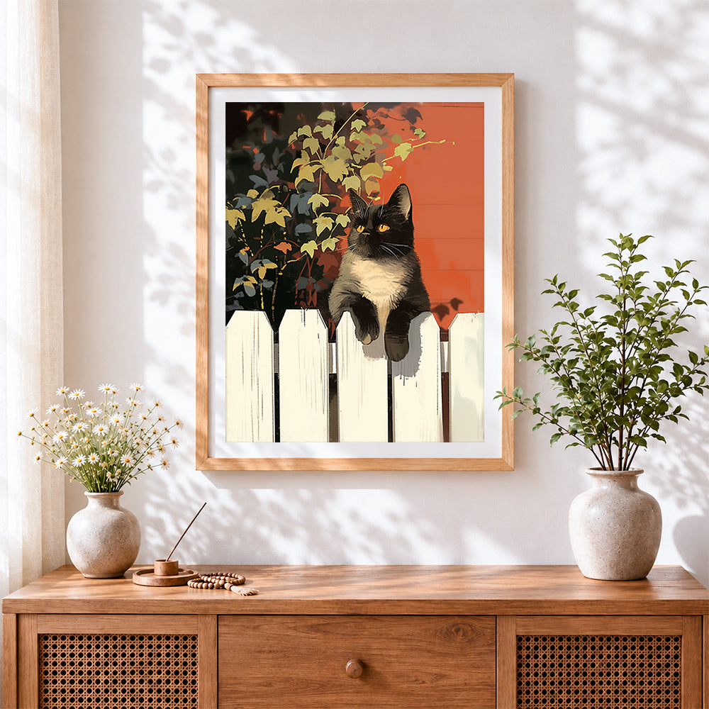 Finished cat on a white picket fence cross stitch artwork displayed