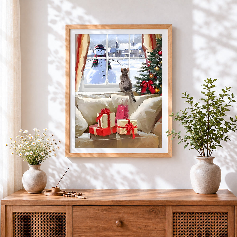 Finished cat on a windowsill watching a snowman outside cross stitch artwork displayed