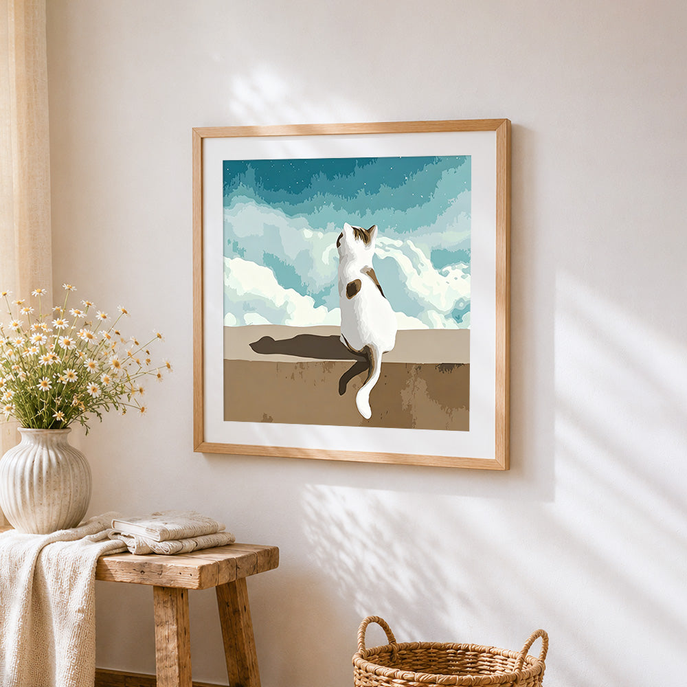 Cat sitting under white clouds cross stitch artwork displayed on wall as home decor
