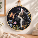 Cat watching butterfly embroidery hoop wall art displayed as warm and cosy handmade home decor