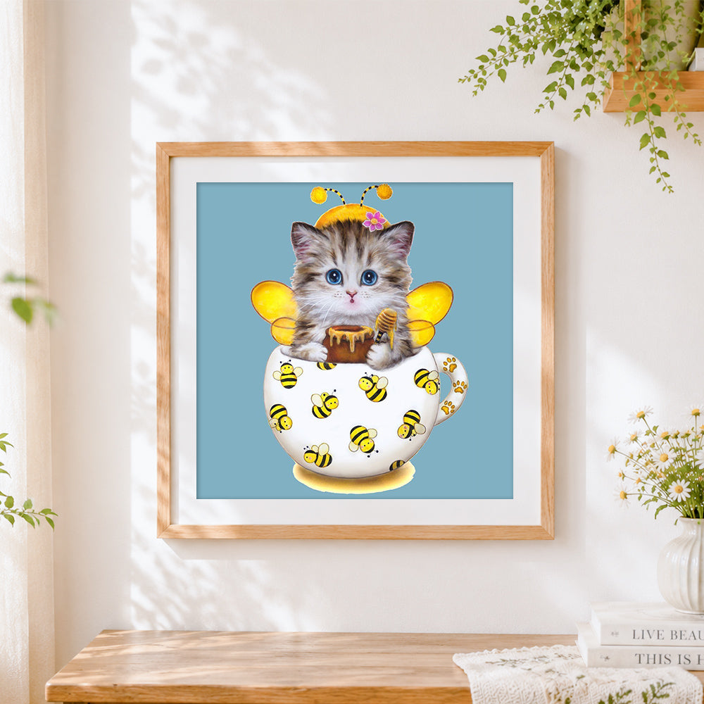 Finished cat with bee costume cross stitch artwork displayed