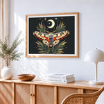 Celestial moth and crescent moon cross stitch artwork displayed on wall as home decor