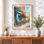 Finished charming blue cafe on a sunny street cross stitch artwork displayed
