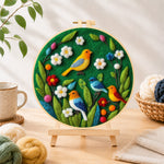 Finished charming flock of colourful birds needle felting displayed on a wooden easel