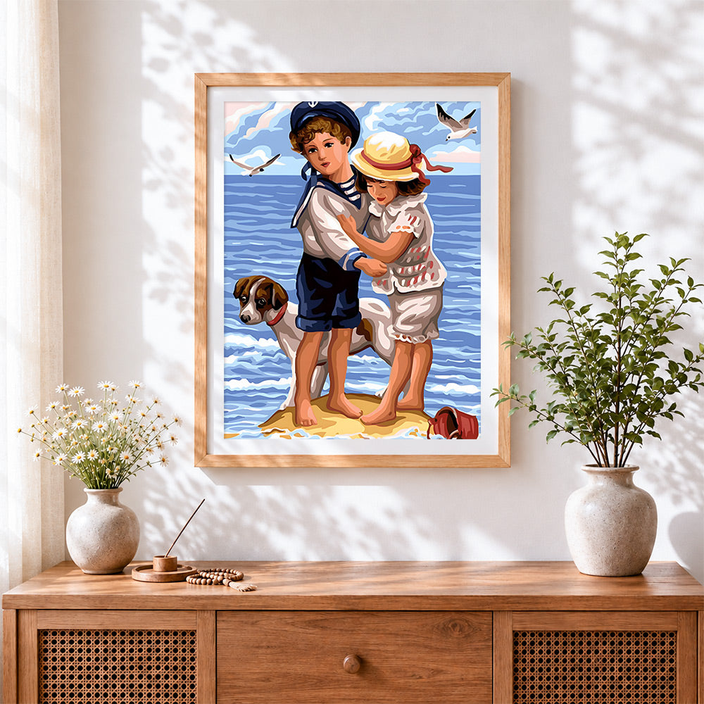 Finished children and dog by the sea cross stitch artwork displayed