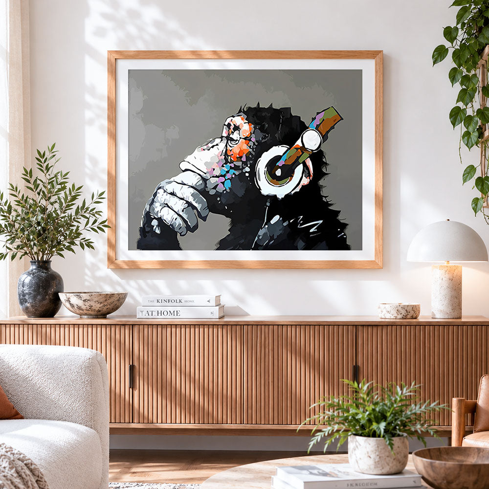 Finished chimpanzee with headphones cross stitch artwork displayed