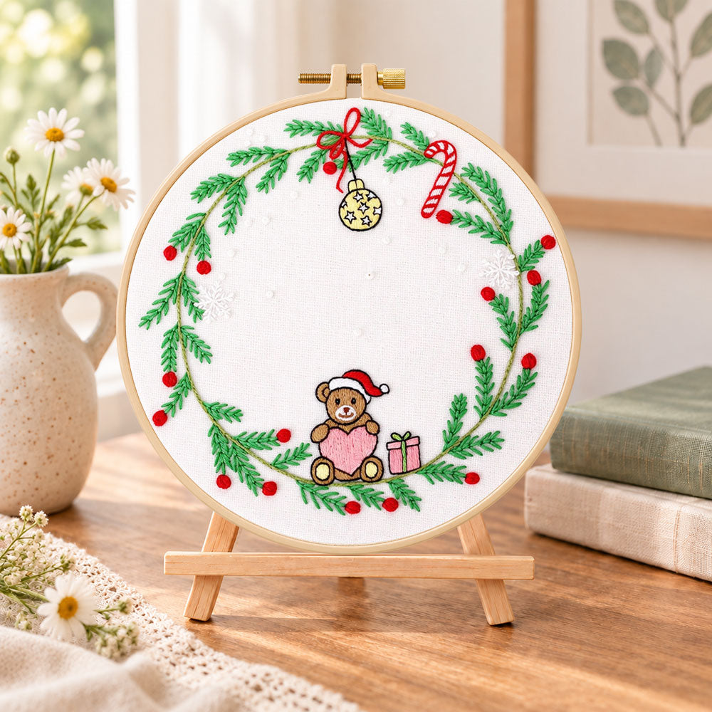 Christmas bear wreath embroidery kit finished hoop displayed on a wooden stand as cosy tabletop decor