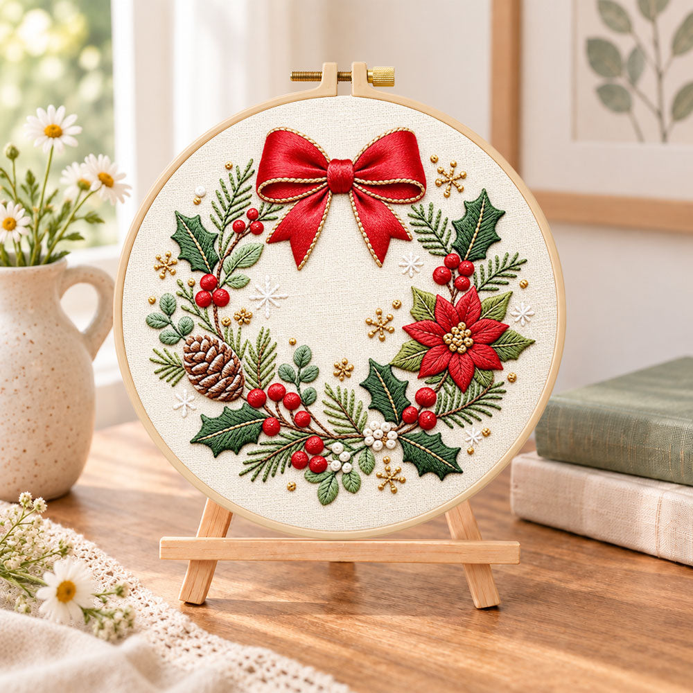 Christmas bow wreath embroidery kit finished hoop displayed on a wooden stand as cosy tabletop decor