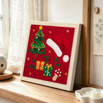 Christmas hat and gifts punch needle artwork displayed on a table