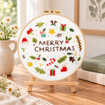 Christmas mini icons embroidery kit finished hoop displayed on a wooden stand as cosy tabletop decor