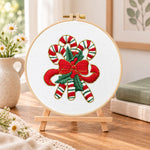 Christmas striped candy cane embroidery kit finished hoop displayed on a wooden stand as cozy tabletop decor