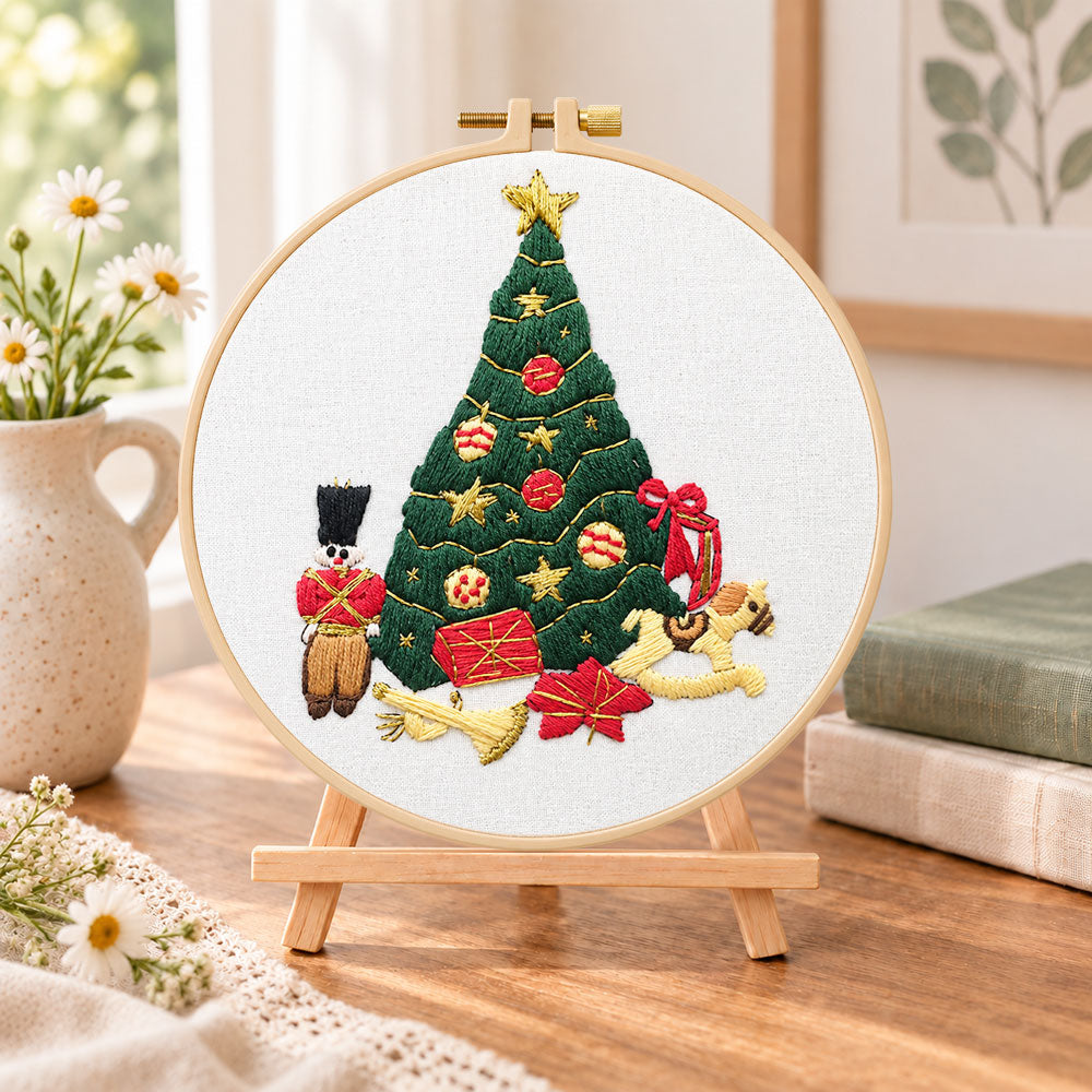 Christmas tree and toys embroidery kit finished hoop displayed on a wooden stand as cozy tabletop decor
