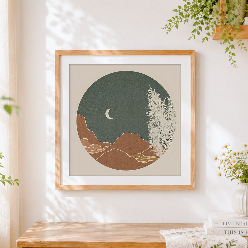 Finished circular minimalist landscape and moon cross stitch artwork displayed