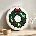 Classic green holiday wreath punch needle artwork displayed on a table