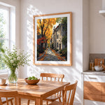 Cobblestone street in autumn cross stitch artwork displayed on wall as home decor
