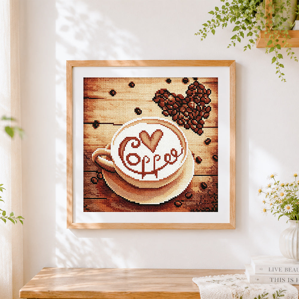 Finished coffee cup and beans cross stitch artwork displayed