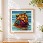 Finished colourful bear in water cross stitch artwork displayed