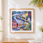 Finished colourful coastal town cross stitch artwork displayed