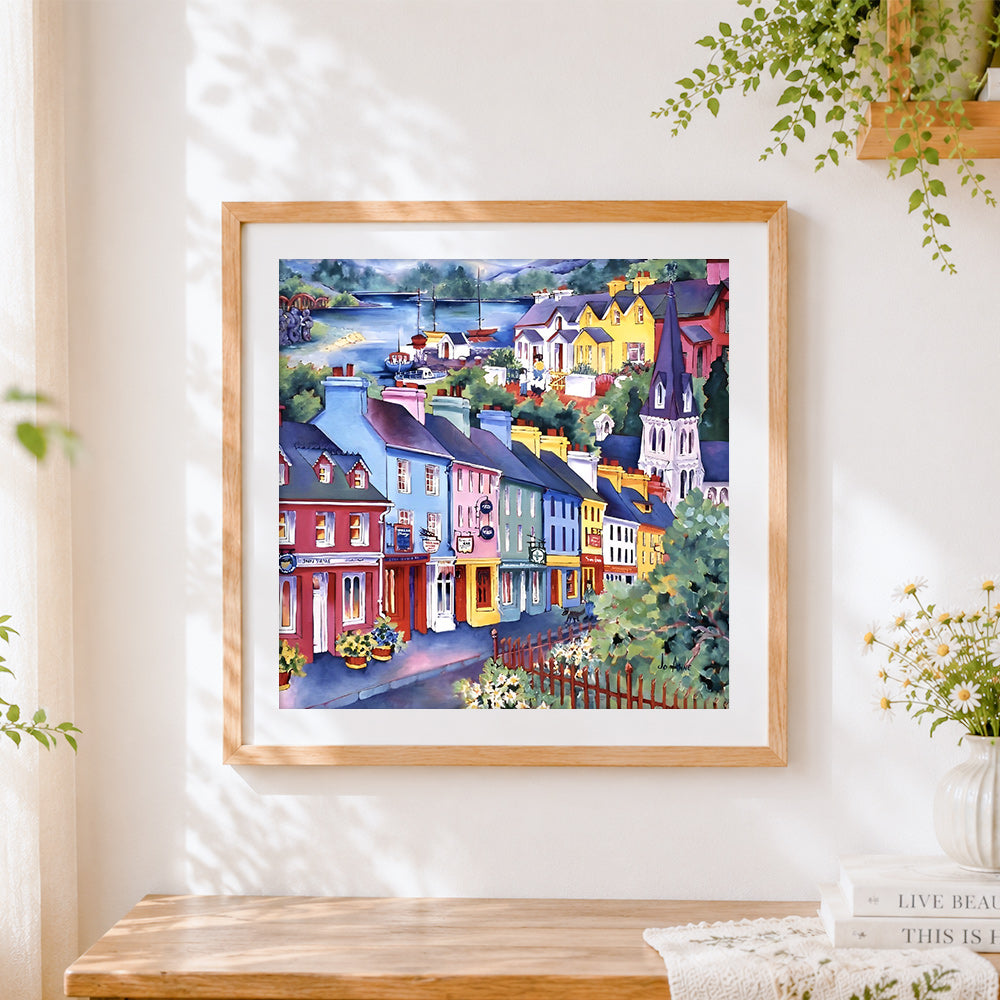 Finished colourful coastal town cross stitch artwork displayed