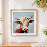Finished colourful cow portrait cross stitch artwork displayed