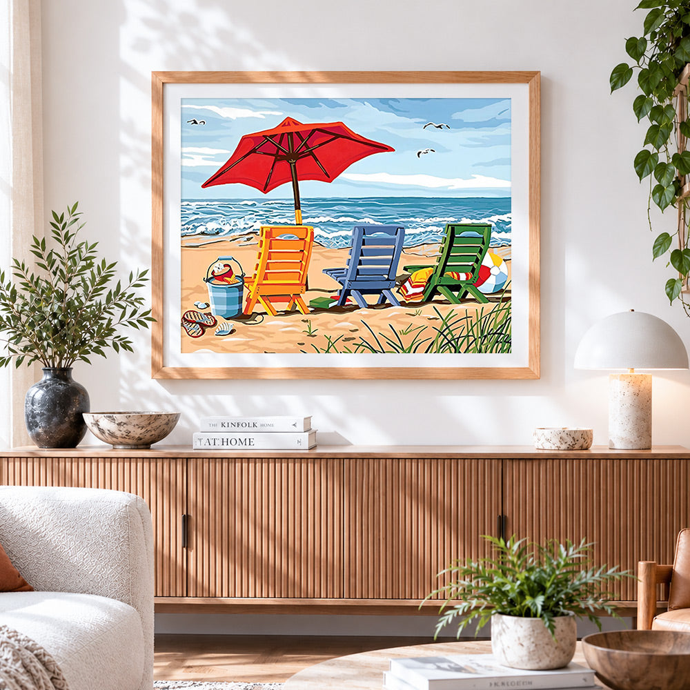 Finished colourful deck chairs on a sandy beach cross stitch artwork displayed
