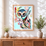 Finished colourful floral owl cross stitch artwork displayed
