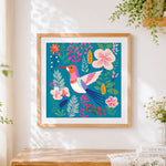Finished colourful folk art bird and flowers cross stitch artwork displayed
